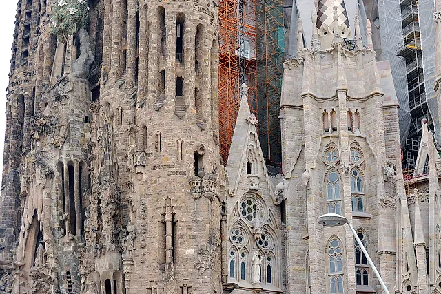 Close view of the carved stone of the basilica, with spires and pinnacles partly covered by scaffolding