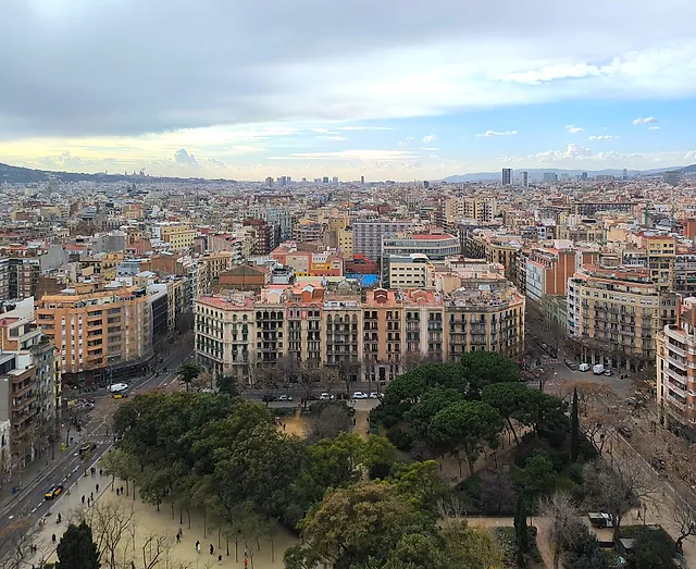 Plaça de la Sagrada Família and its park seen from above, with the streets of the Eixample stretching toward the city
